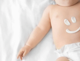 bebé con crema en el abdomen